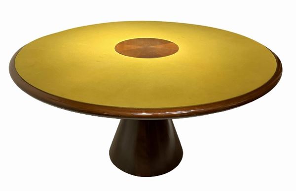 Italian Production in the style of Angelo Mangiarotti. Important table with wooden frame furs walnut wood and glossy finish. Foot frustum-shaped and round surface covered with cloth in shades of mustard. Signs of use. 70's.