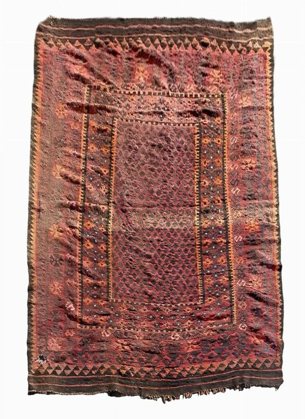 Tappeto nei toni del rosso, con bordi con strisce arancioni su fondo marrone. Cm 271x186. Presenta segni di usura e una piccola mancanza