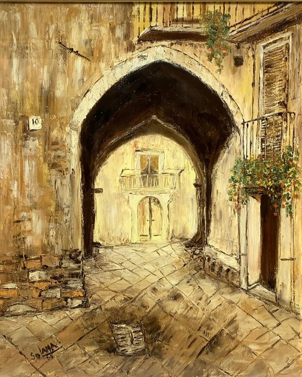 Strada di paese con arco a sesto acuto.