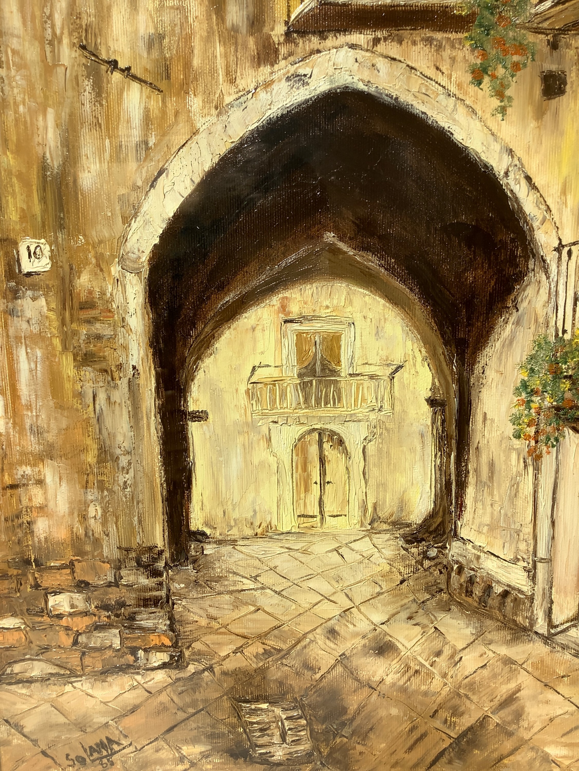 Strada di paese con arco a sesto acuto.