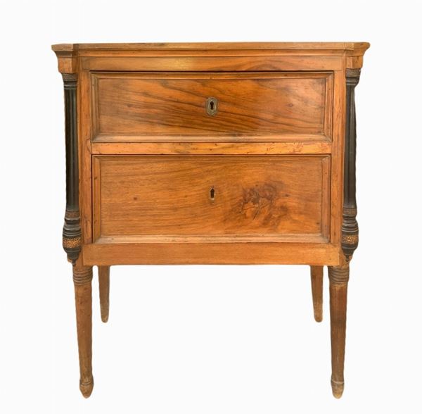 Two-drawer walnut wooden bedside table with black ebonal columns on the sides.