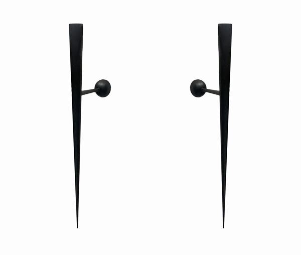 Prod. Lumen. Pair of black lacquered metal wall lights with lanceolate structure.