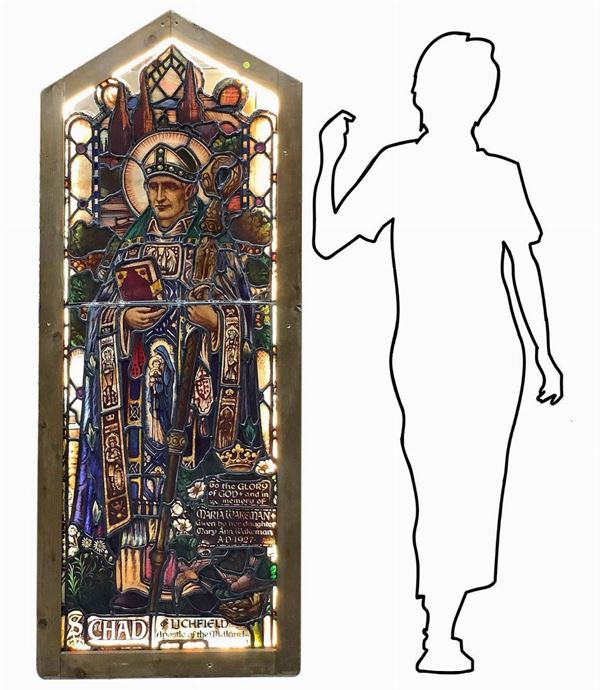 Antica vetrata rilegata a piombo con immagini a infusione nel vetro raffigurante San Chad di Mercia, abate e vescovo britannico. In telaio in legno, larga cm 6. H cm 169. Larghezza cm 67. Retroilluminata. Piccole rotture.
