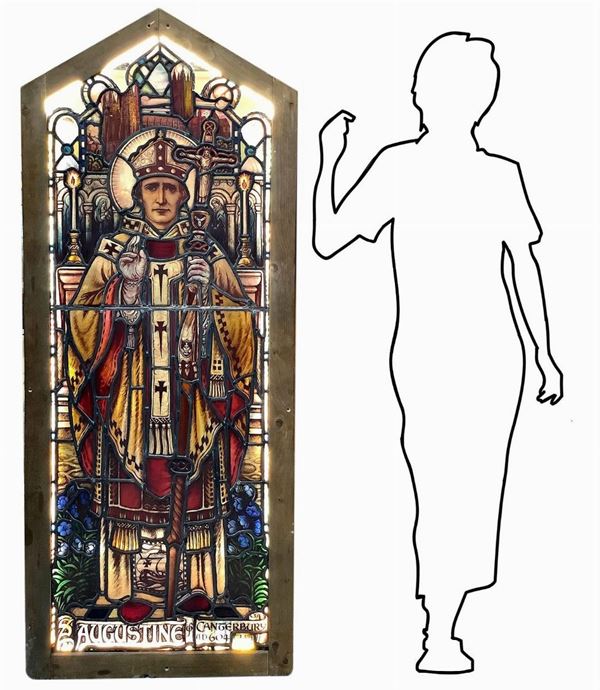 Antica vetrata rilegata a piombo con immagini a infusione nel vetro raffigurante Sant Augustine. In telaio in legno, larga cm 6. H cm 169. Larghezza cm 67. Piccole rotture.
