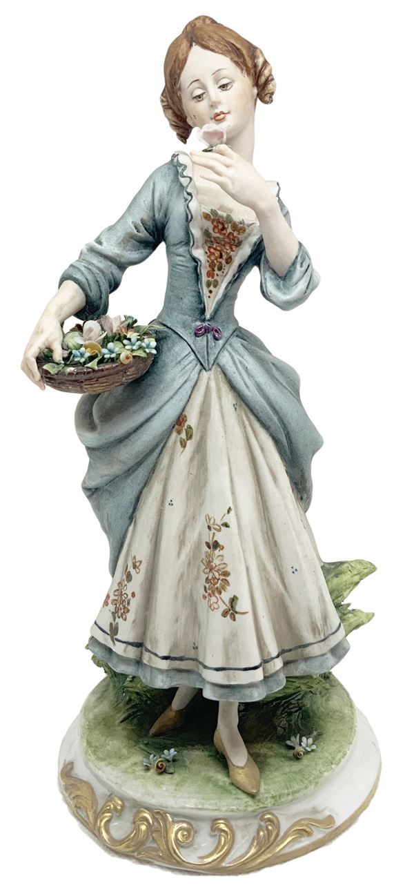 Statuetta in porcellana di Capodimonte raffigurante dama con cesto di fiori.