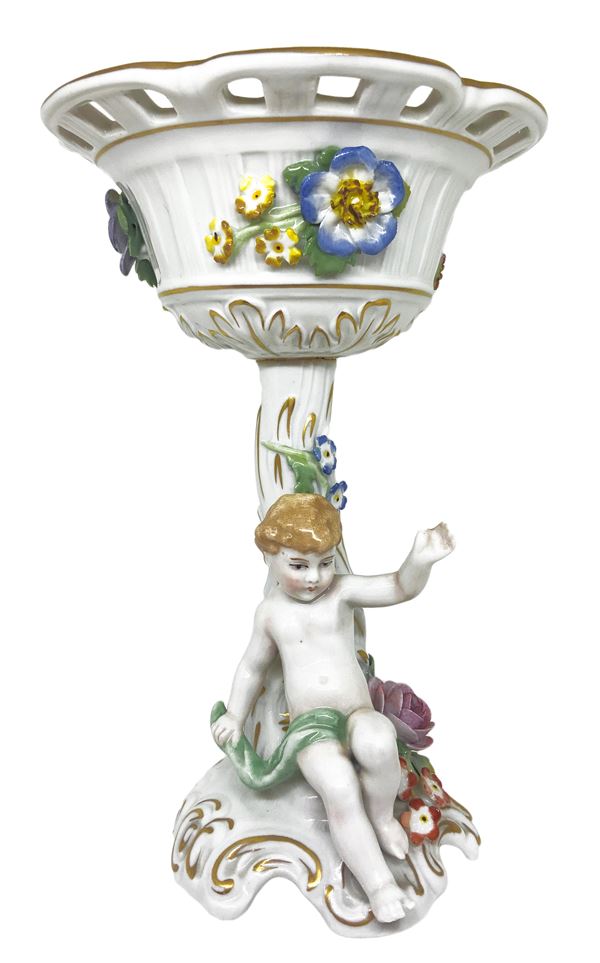 Alzata in porcellana di Capodimonte con decori floreali e piccolo amorino alla base.