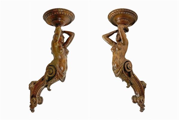 Sculture lignee raffiguranti cariatidi, donne a dorso nudo reggenti mensola