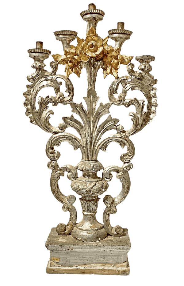 Candeliere in legno argentato e dorato a cinque candele, figurato a vaso con foglie e fiori.