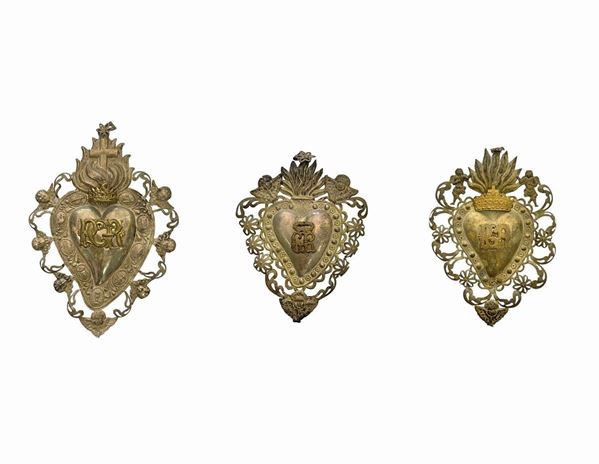 N 3 Ex voto in argento a forma di cuore con puttini e simboli della passione. 1) H cm 23 2) H cm 17 3) H cm 20