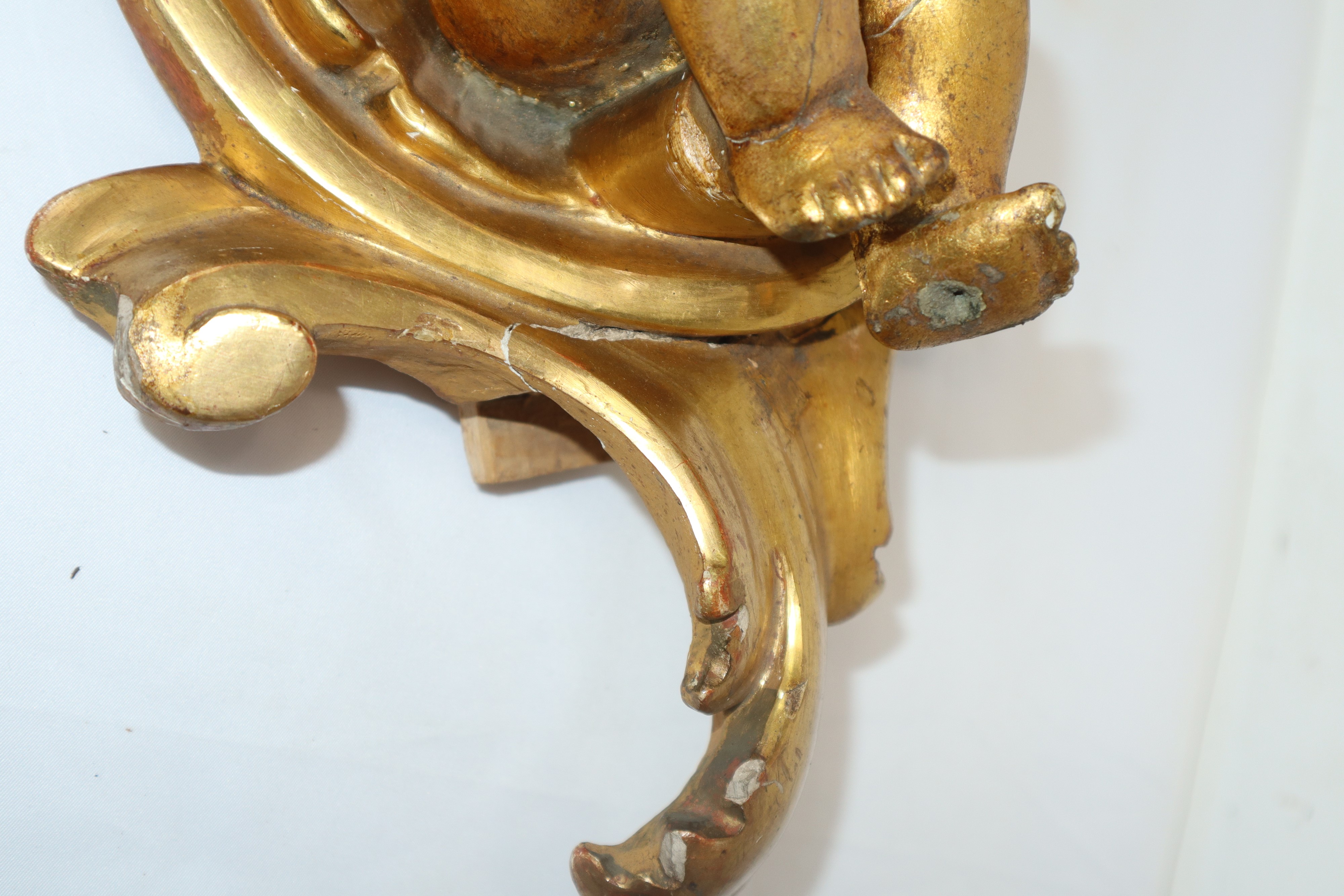 Putto, terracotta dorata a foglia con conchiglia e base in legno dorato, fine XIX secolo