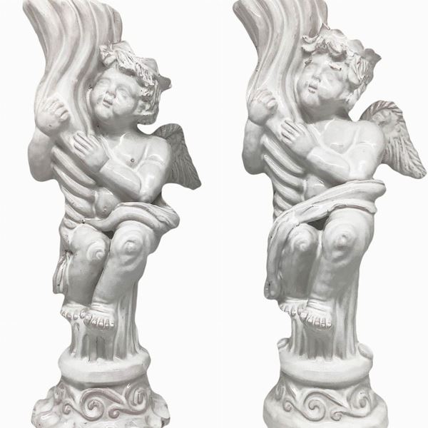 Coppia di candelieri in maiolica bianca di Caltagirone con puttini reggicandela