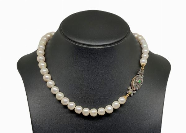 Pearl Necklace 42 cal. 11-11 ½ susta in gold and silver with central emerald and diamond small roses