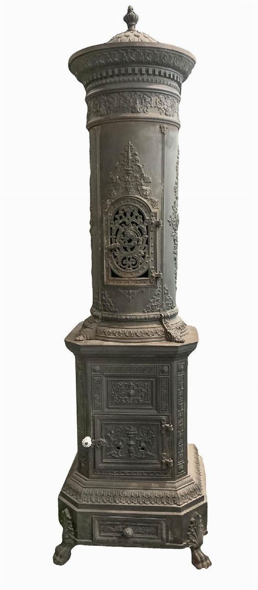 Stufa in ghisa, XIX secolo. Con base quadrangolare con piedi leonini sbalzata con decori neorinascimentali e stilemi floreali. H cm 195. Base cm 60x60. H cm 82. Scarico fumo. H cm 132. Diametro cm 12.