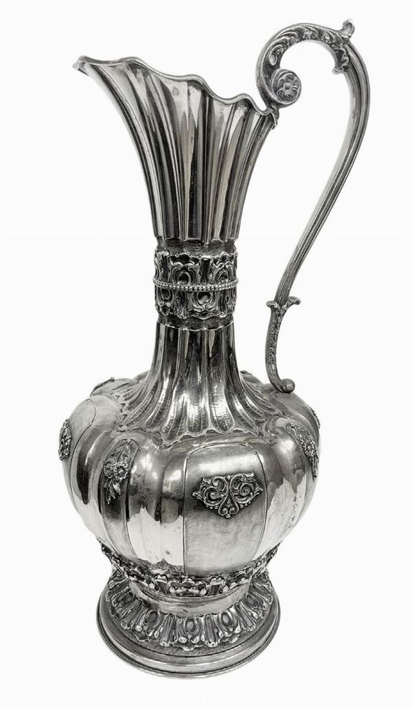 Important pitcher silver, early twentieth secolo.Con handle, lobed body and embossed. H cm 41. 1.474 Kg.

