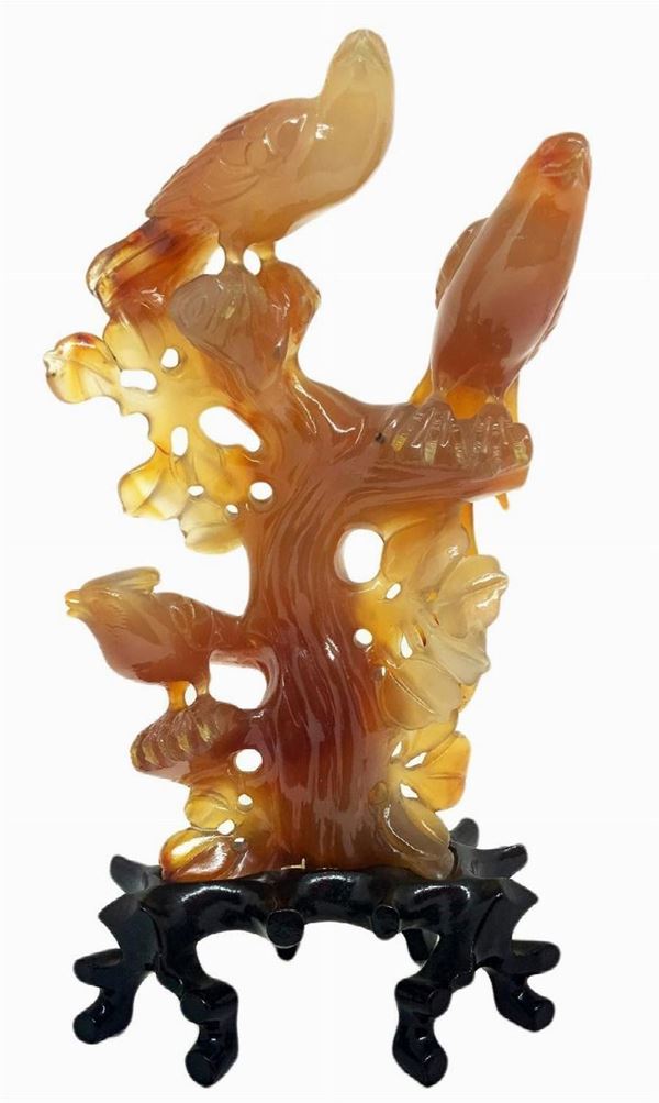 Statuetta in corniola di colore bruno chiaro trasparente raffigurante tre uccelli del paradiso su un albero. Provenienza Pechino Primi anni del ‘900. H cm 16. H con base cm 20. Base cm 6.