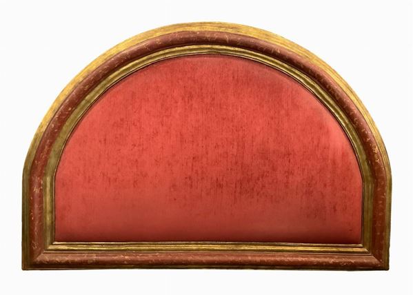 Testata da letto realizzata con cornice a mezza luna laccata nelle tinte del rosso screziato e dorata a foglia, XVI secolo. H cm 150 X cm 220