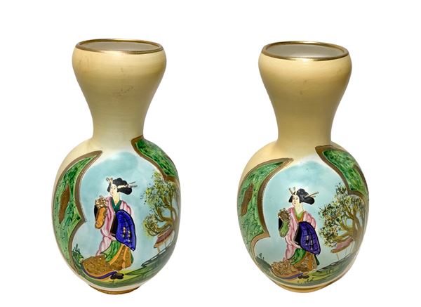 Pair of vases painted with Chinese genre scenes, gold inserts on a beige base.