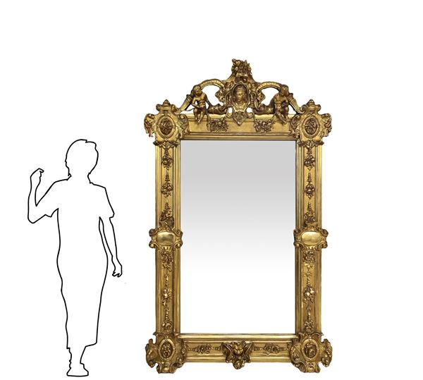 Importante specchiera in legno dorato a foglie d'oro