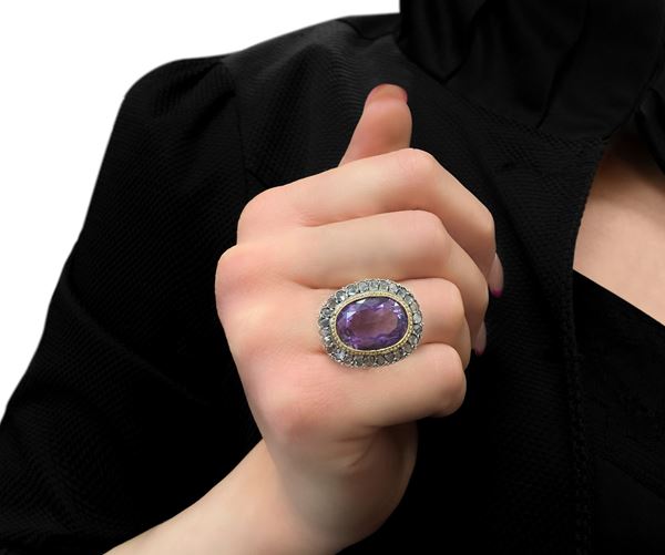 Low title ring with central faceted amethyst with diamond crown