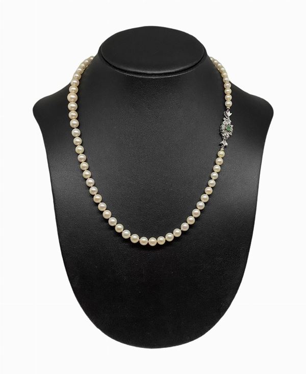 Pearl necklace with white gold clasp and central emerald.