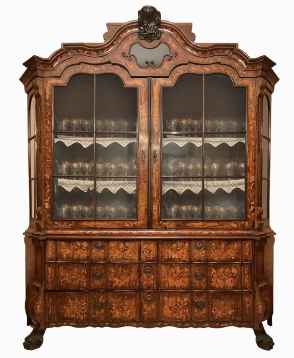 Cristalliera olandese del XVIII secolo a due ante a vetri superiori e sei cassetti alla base. Intarsi in legni chiari sul fronte e sui laterali.
H cm ... 