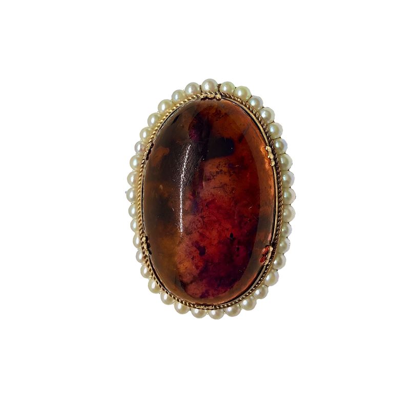 Spilla con ovale in ambra e contornata da perline