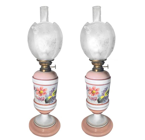 Belgica D.F. - Coppia di lumi a petrolio in ceramica nei colori del bianco e del rosa con decorazioni floreali e boccia a tulip in vetro del'epoca 
