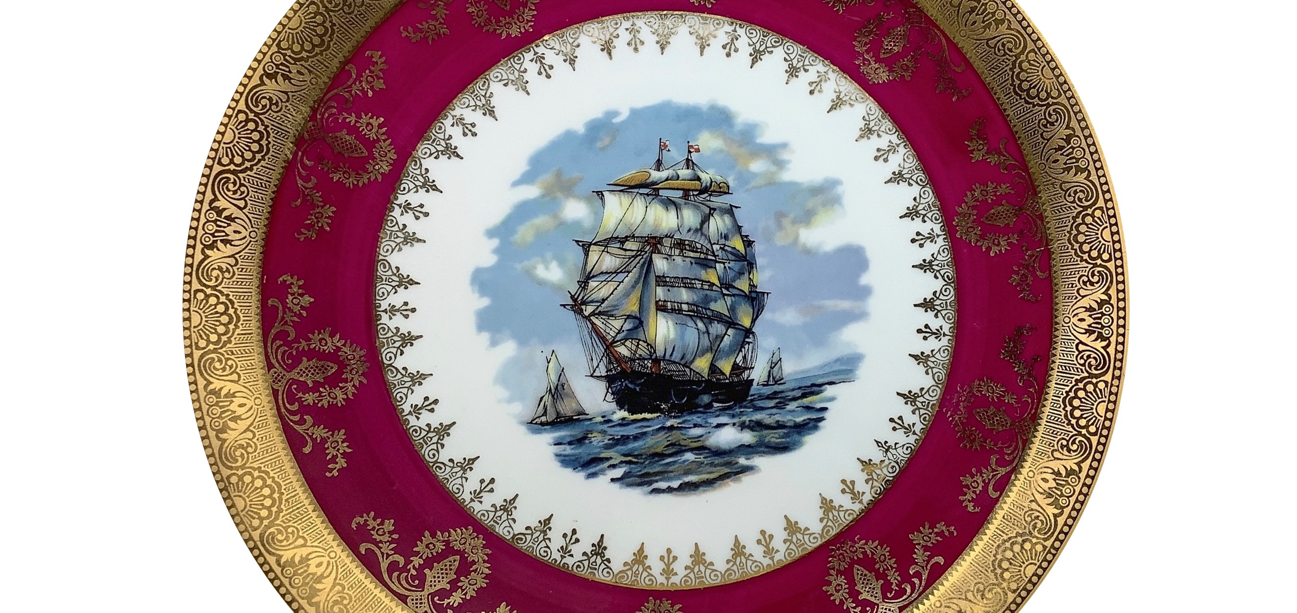 Coppia di piatti in porcellana bordeaux e oro con un galeone al centro