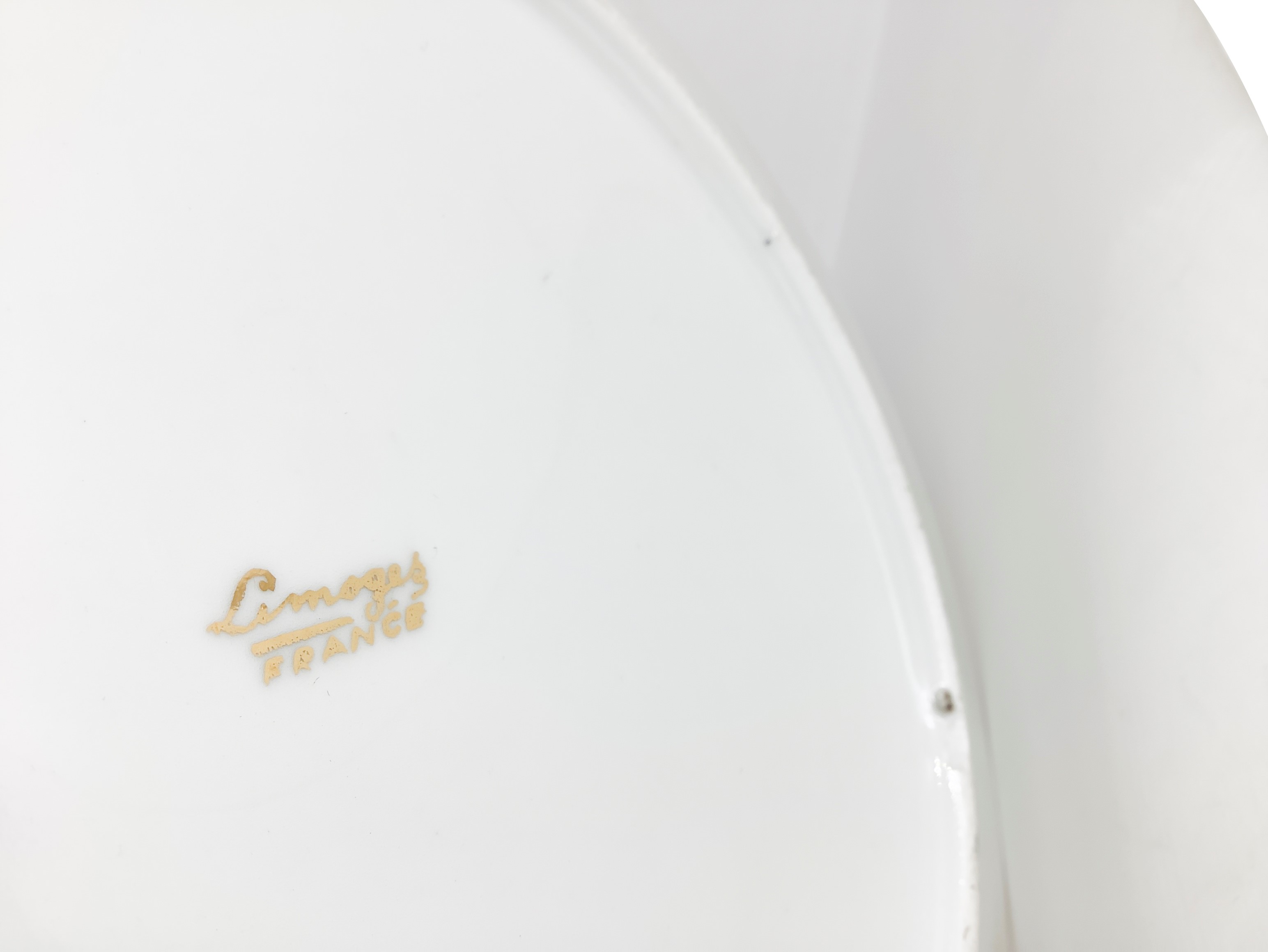 Coppia di piatti in porcellana bordeaux e oro con un galeone al centro