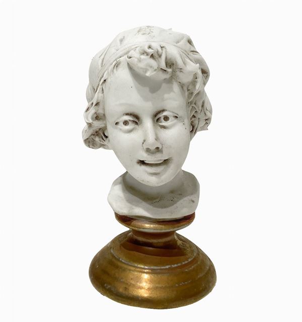 Small biscuit head on a gilded porcelain base. Signed on the back.