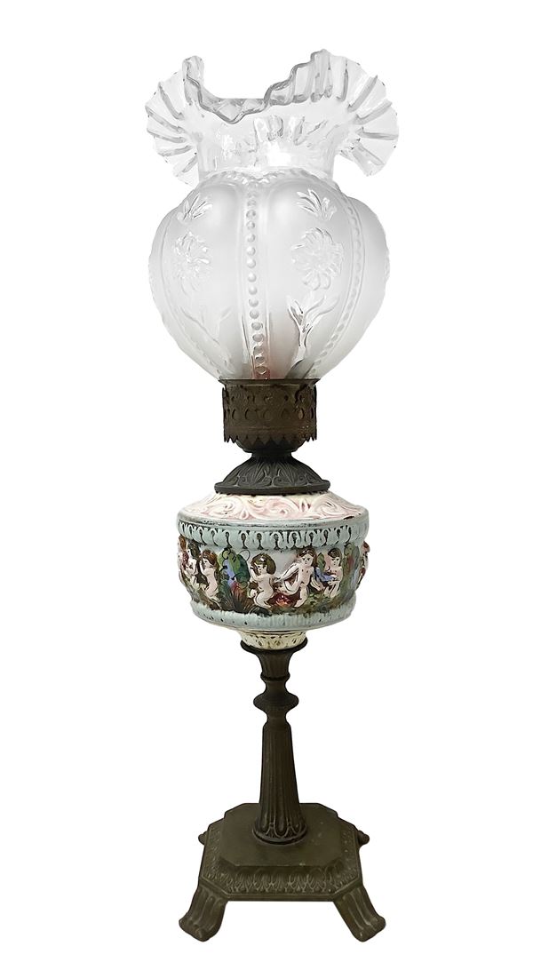 Majolica lamp painted with colored embossed cherubs, brass base and tulip glass bowl