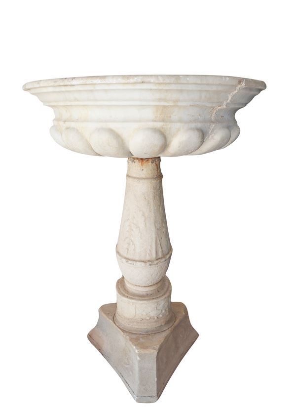 Holy water stoup in white marble
