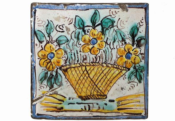 Calatgirone majolica tile with flower basket decoration in shades of yellow, blue and manganese