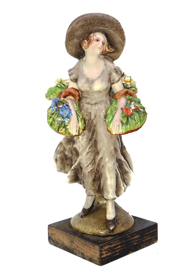 Statuina in ceramica raffigurante dama con cesto di fiori