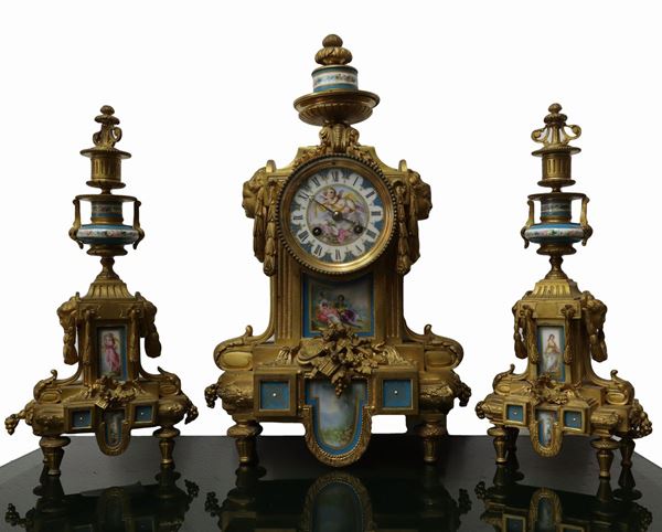 Trittico con orologio e coppia candelieri in bronzo dorato e porcellane miniaturizzate 