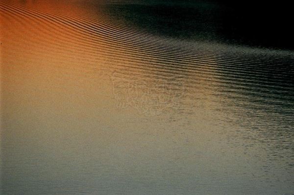 Collezione AQUA, titolo "Frequenze", anno 2005. Svizzera: lago di Morcote, onde sull'acqua grigio/nero/arancio, diapositiva 0 / 5, 70x100, stampa digitale Fine Art su carta fotografica mat kodak, forex nero 20mm, bordato