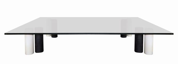 Low square table with support feet formed by cylindrical geometric elements in marble.