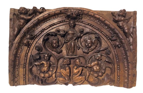 Fragment of walnut wood carved frieze depicting Saintta Barbara with putti and satyrs, XVII / XVIII century. Cm 42x67