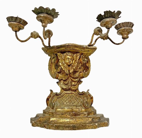 Mensola portacandele a quattro luci in legno dorato a foglia, Sicilia, XVIII secolo. Con braccetti e colacera in metallo. H complessiva cm 33. Base maggiore cm 30, base minore cm 19,5
