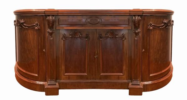Credenza bassa in legno di mogano con interni foderati, cassetto centrale superiore più due sportelli angolari e due centrali. Intagli di legno a ghirlanda applicati. H cm 98, lunghezza cm 210, profondità cm 66