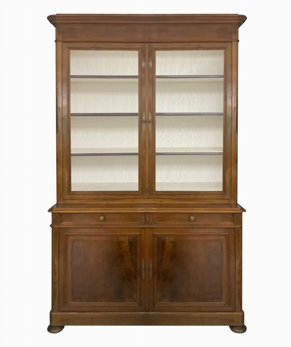 Credenza a due corpi. Provenienza Italia,in legno di noce nazionale chiara, corpo superiore a due ante in vetro, base con due sportelli, provenienza ... 