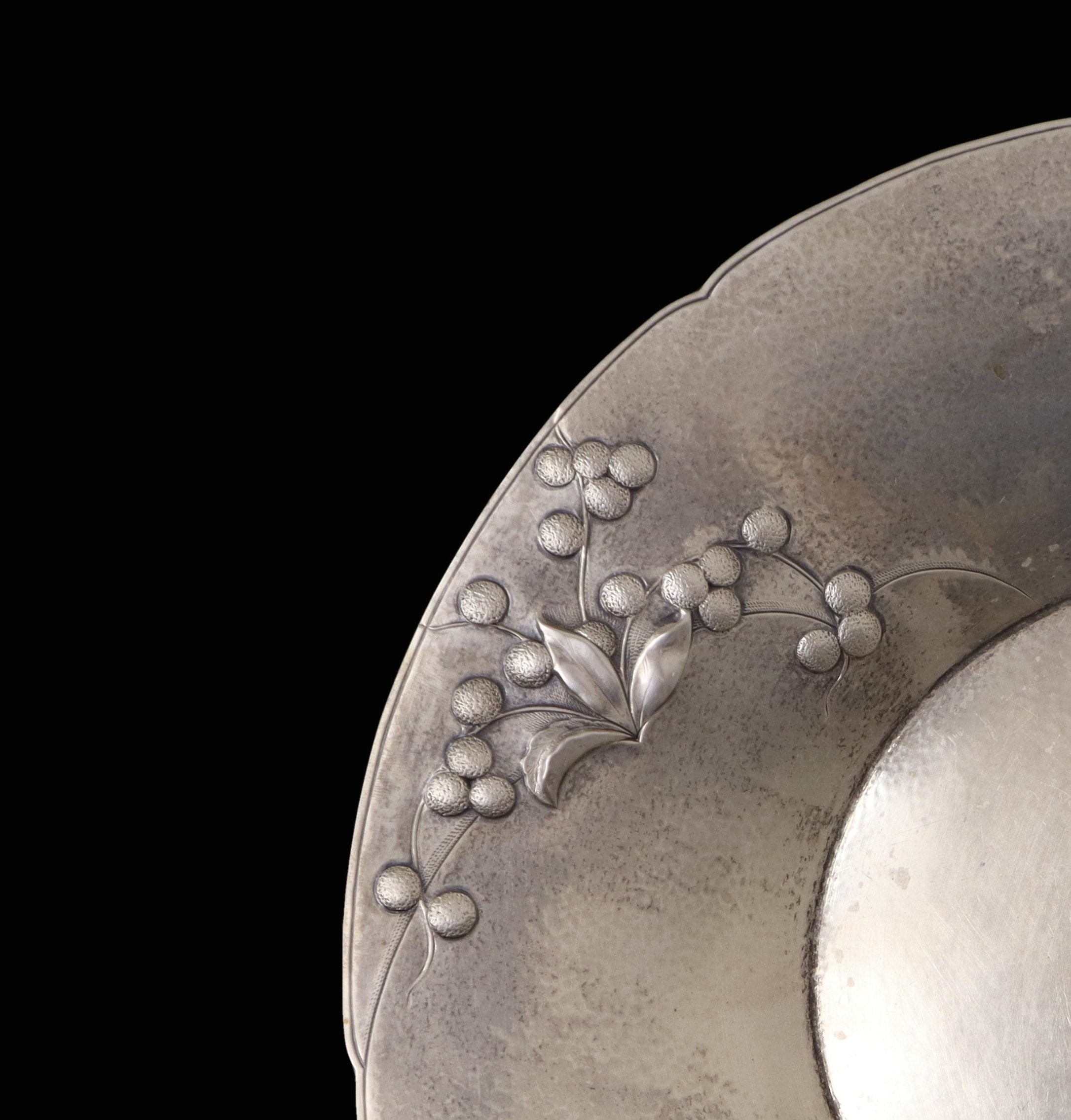 Piatto in argento 800, sbalzato a motivi floreali
