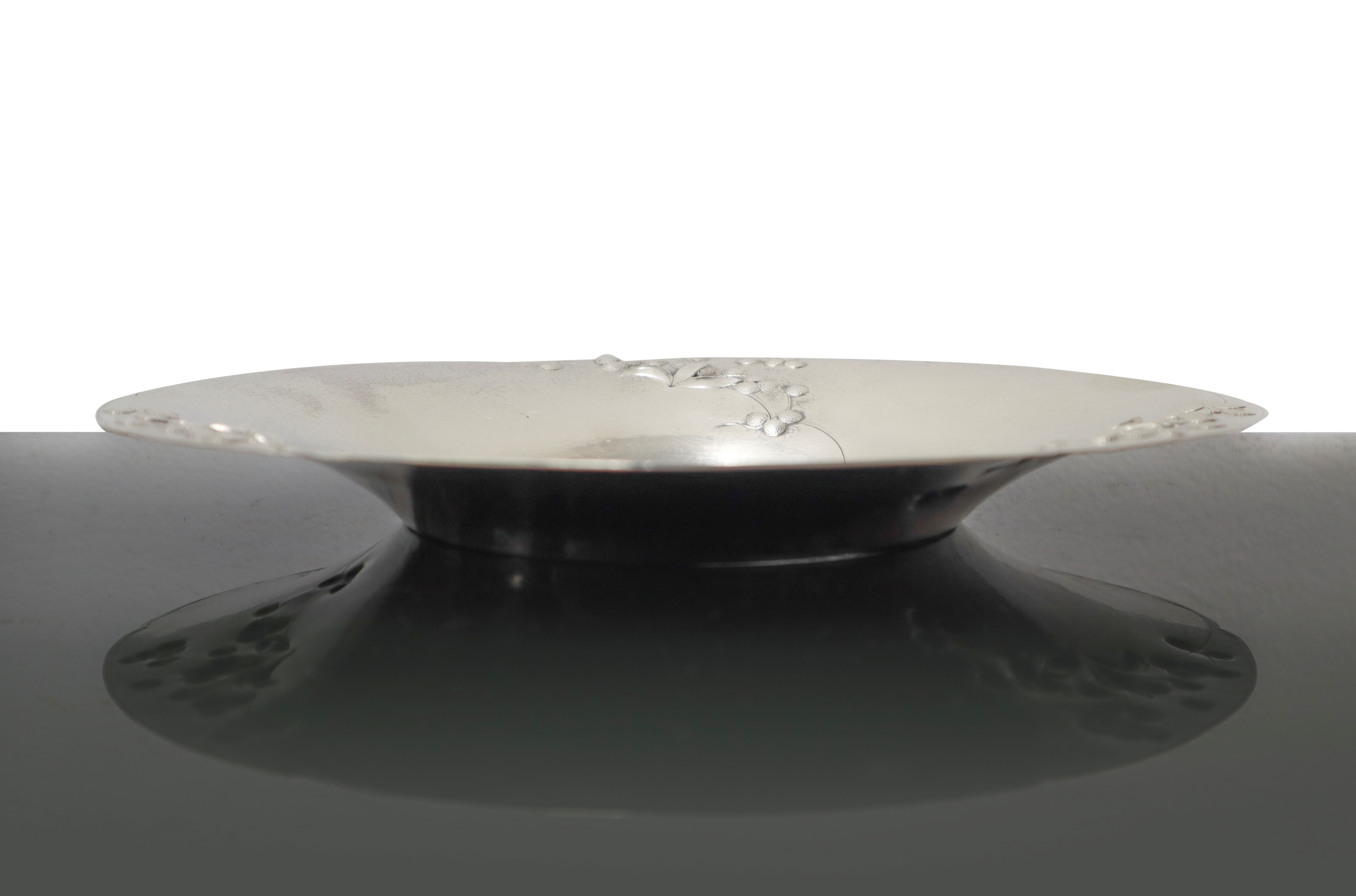 Piatto in argento 800, sbalzato a motivi floreali