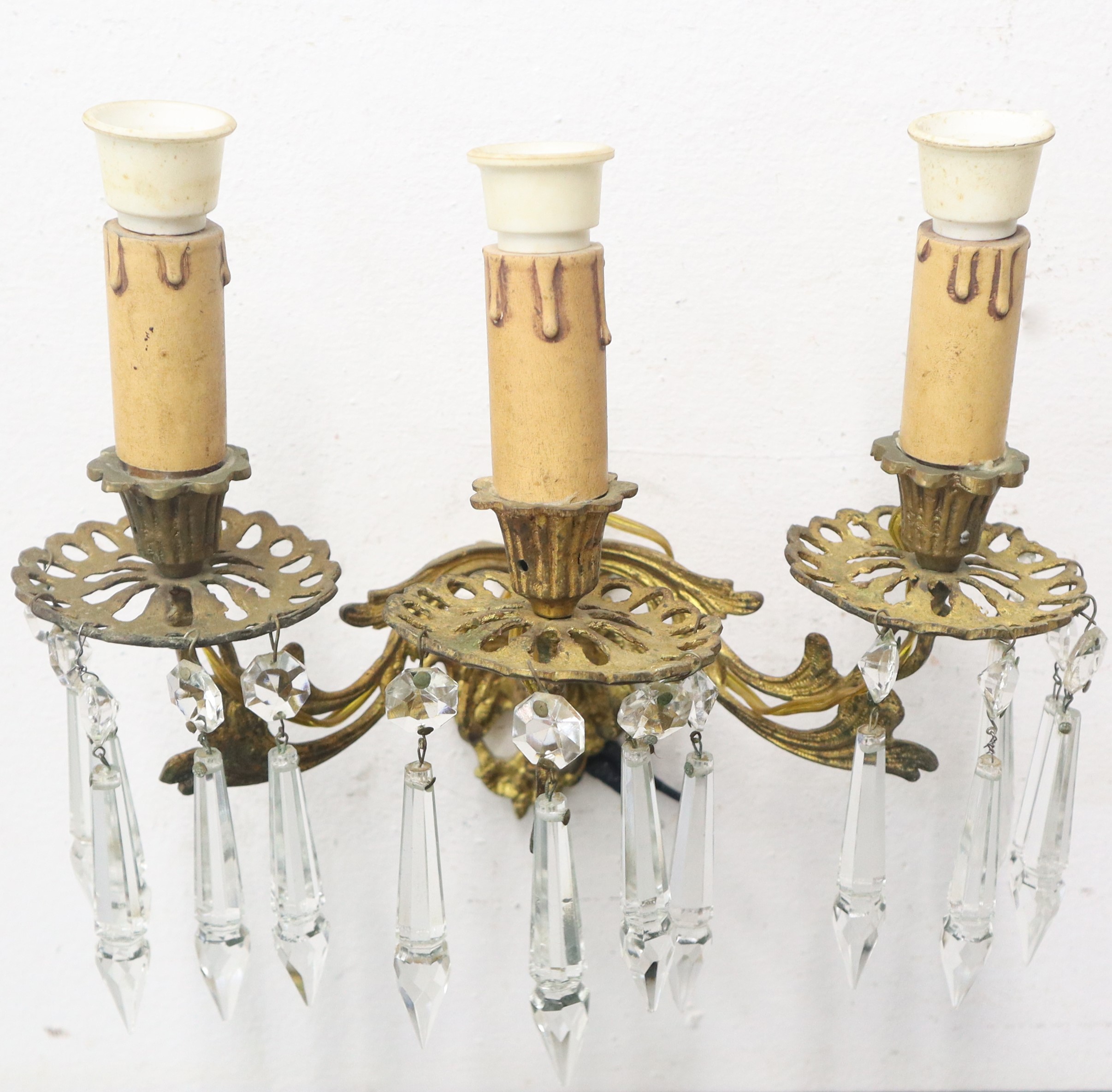 Coppia di applique in metallo dorato a tre luci