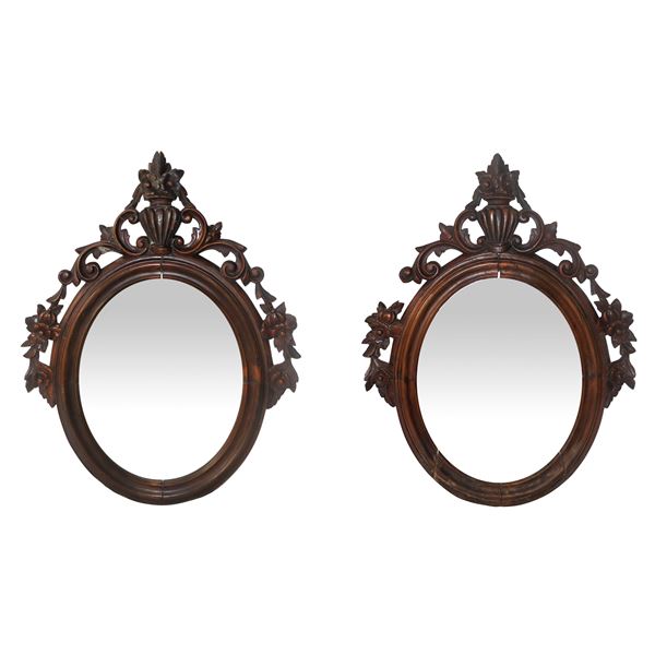 Pair of oval mirrors with applied floral motif carvings.
