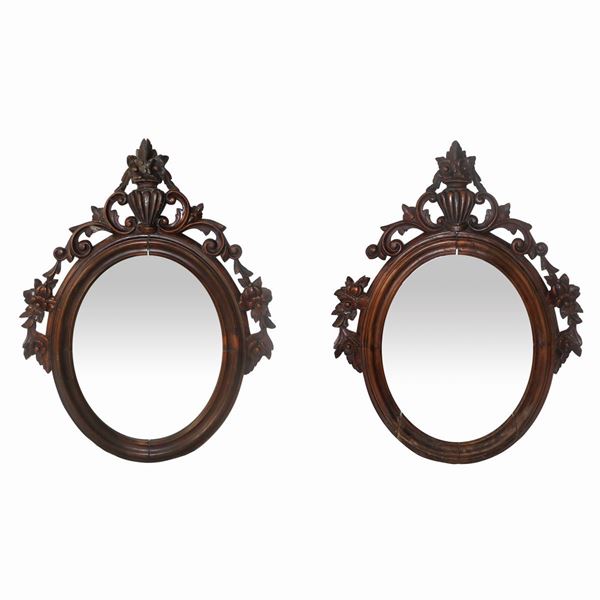 Pair of oval mirrors with applied floral motif carvings.