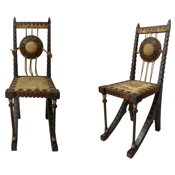 Carlo Bugatti - Extremely rare pair of chairs, in ebony-stained, worked and turned walnut, embossed copper decorations, bone inlays, leather seat.