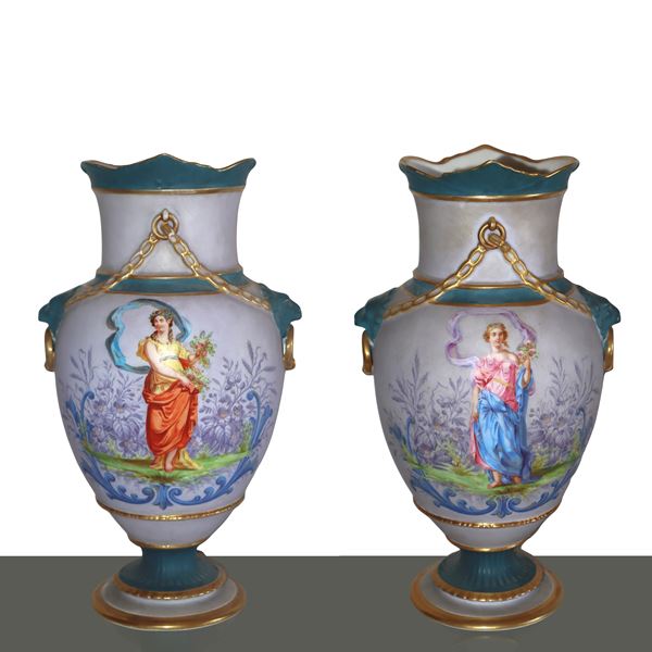 Coppia vasi in porcellana dipinta con raffigurazione di figure femminili, finiture in oro e maniglie leonine