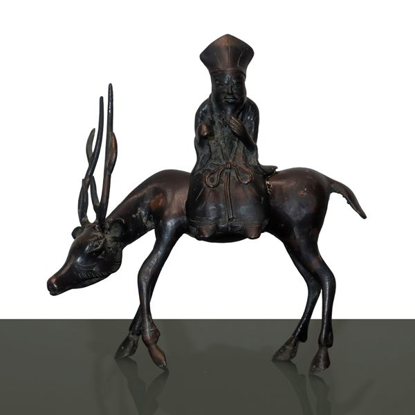 Bronze elder sitting on deer