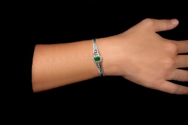 White gold bracelet with central emerald and 16 brilliant cut diamonds.